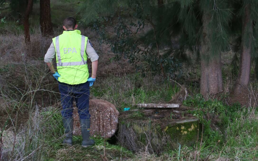 An EPA worker inspects the scale of the sewage spill in Long Gully Creek on July 31, 2013.