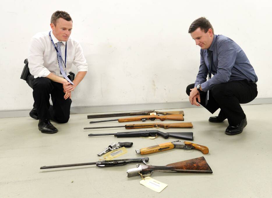 Detectives James O'Bree and Ben Manning with guns seized by Bendigo police. Picture: DARREN HOWE