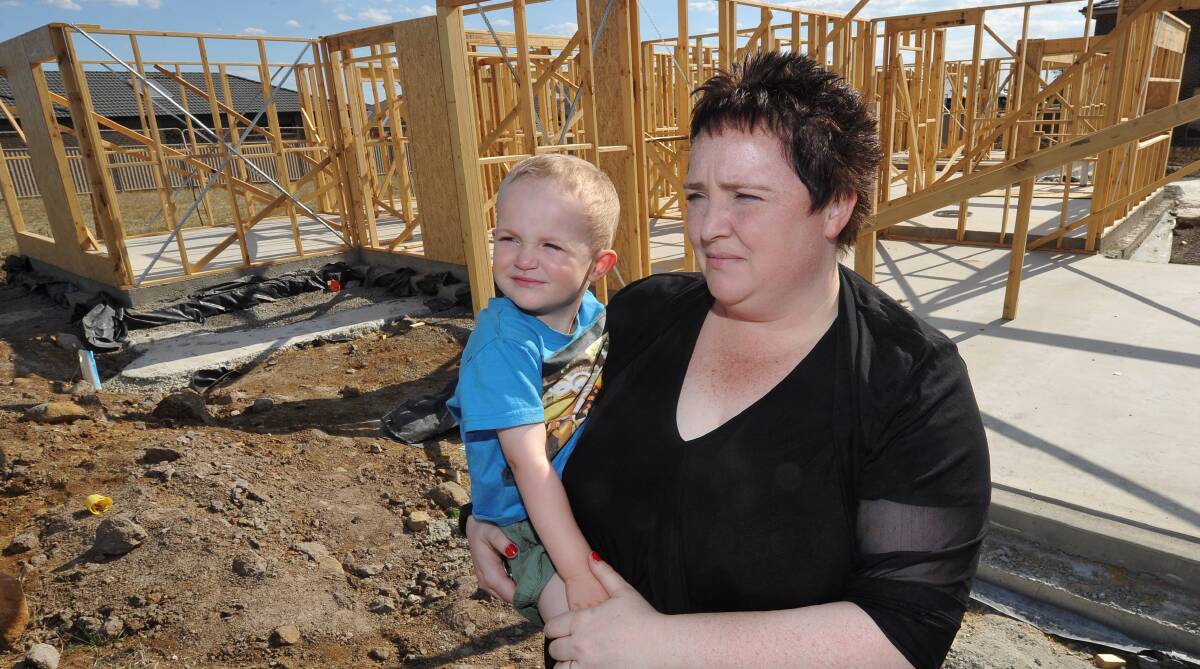 Kick in the guts: Sue Emery with her son, Tanner, 3, at the concrete slab they had hoped would be their dream home in Delacombe. Picture: Lachlan Bence.