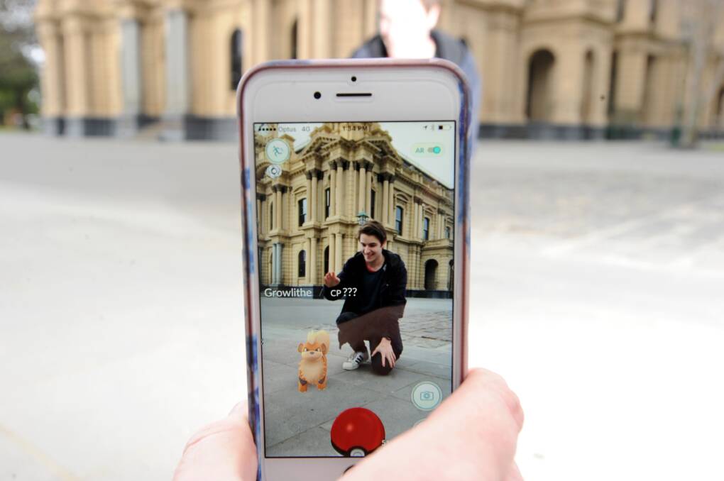 Eamon Willis with a Growlithe in front of Bendigo Town Hall. Pokémon Go's popularity has risen rapidly in Bendigo, with a community of at least 2000 users. Picture: NONI HYETT