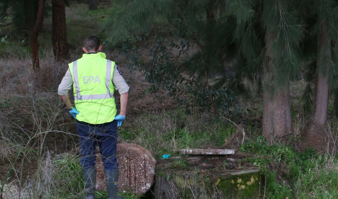 An EPA worker inspects the scale of the sewage spill in Long Gully Creek on July 31, 2013.