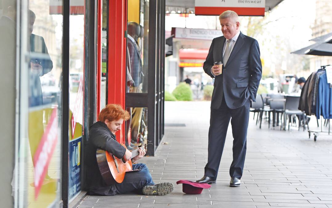 Communications minister Mitch Fifield listens to a busker in Hargreaves Mall, before announcing $245,000 for extra CCTV cameras. Picture: DARREN HOWE