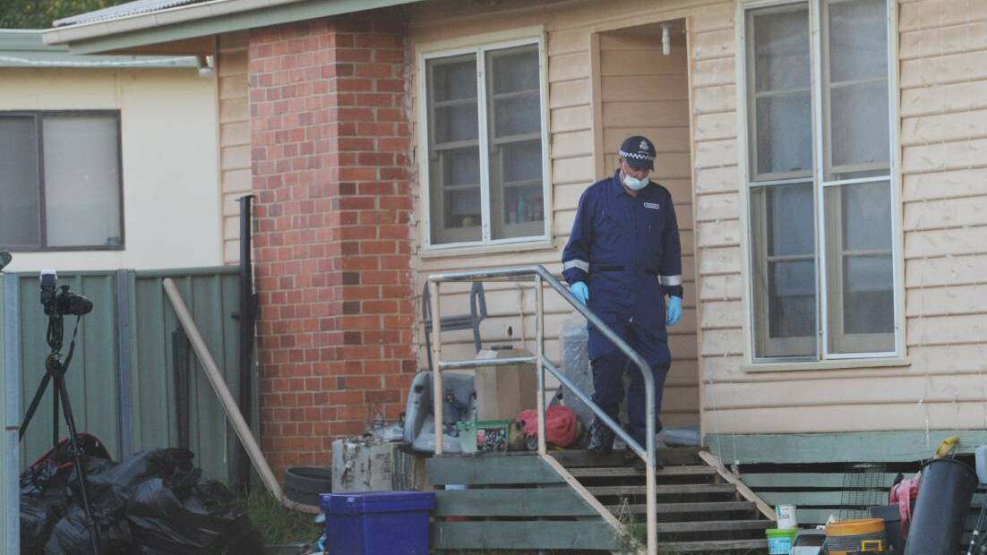 A detective leaves the house shared by Christine Lyons, Ronald Lyons, Peter Arthur and murder victim Samantha Kelly. Picture: DARREN HOWE