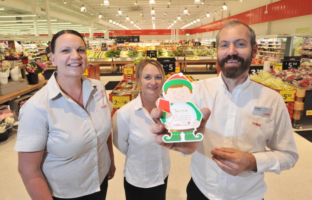 Kangaroo Flat Coles staff members Sarah Richards, Tania King and store manager Lloyd Hagar with one of the fundraising cards. The store was one of the top fundraisers in Australia. Picture: NONI HYETT