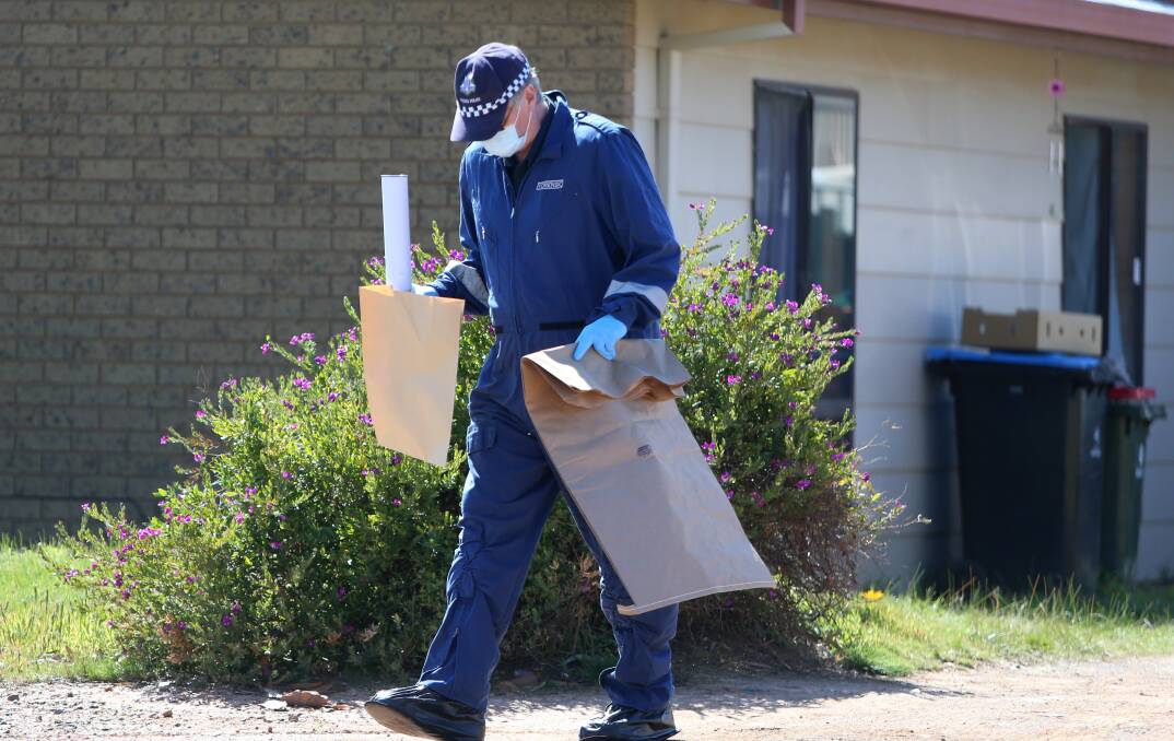 Police collect evidence after the stabbing, which left blood smeared on the walls and a pool of blood in the kitchen. Picture: GLENN DANIELS