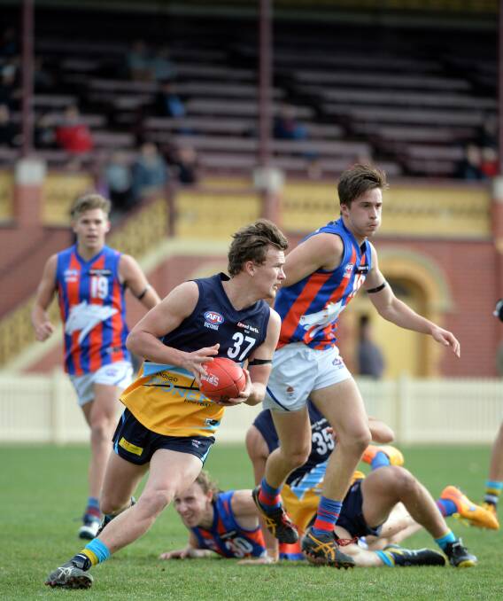 ON THE RUN: Riley Hogan clears from the Bendigo Pioneers defence in the 12th round clash with Oakleigh Chargers at the Queen Elizabeth Oval. Oakleigh star Dan Houston (19) looks on. Picture: BILL CONROY