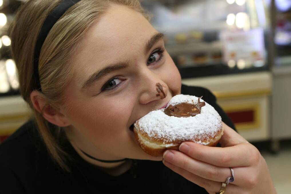 YUM: Chloe Sanders bites into a Nutella doughnut. Picture: PETER WEAVING
