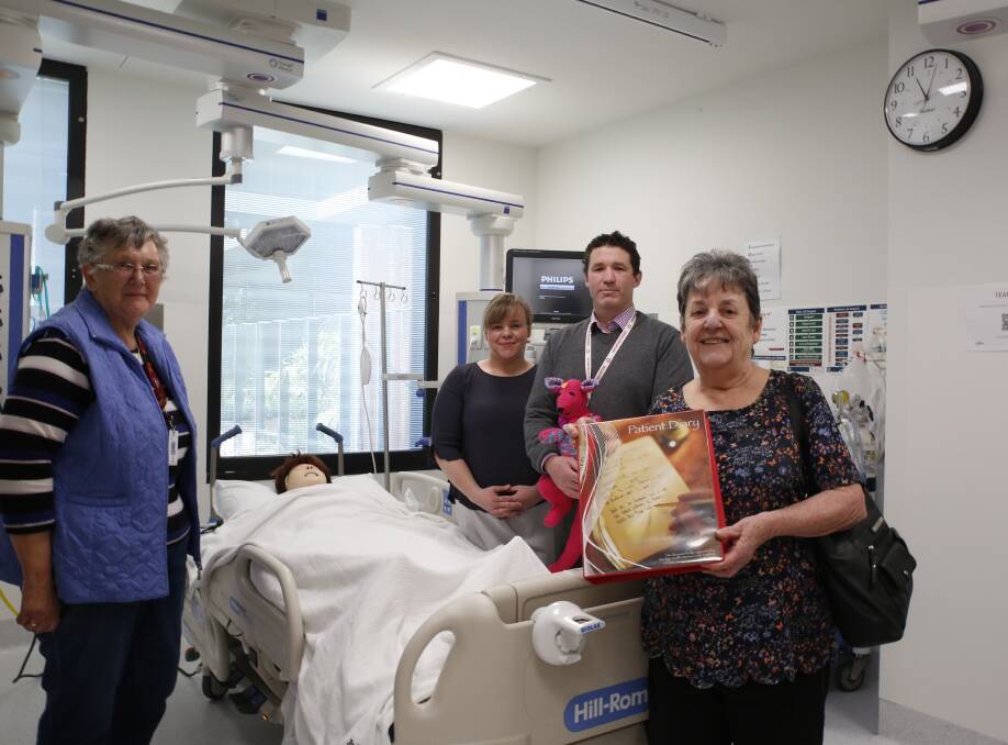Val Coghill, Jenni Tuena, Darcy Bales and Beth Benbow with an ICU patient diary in the new hospital's simulation room.