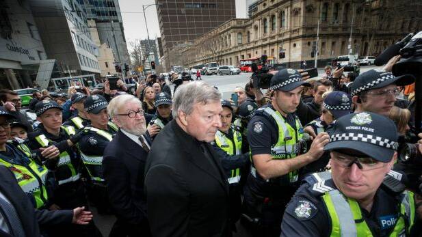 Cardinal George Pell with his lawyer Robert Richter, QC, leaving court amid chaotic scenes. Photo Jason South