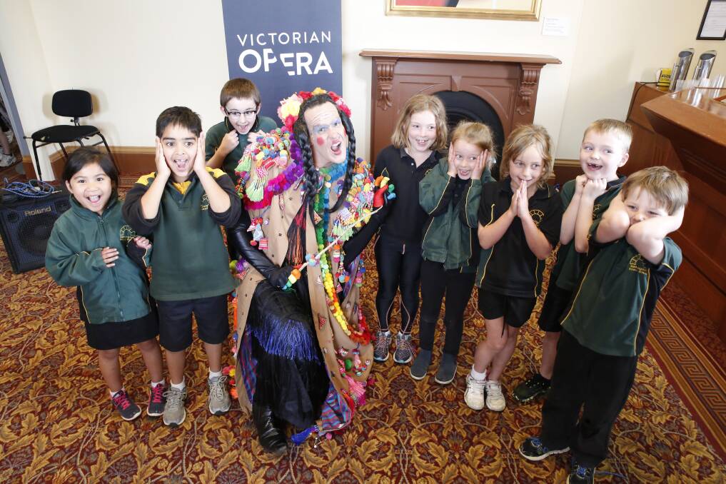Kennington Primary School students get a fright while posing with Carlos Bárcenas, who plays the witch in Victorian Opera's production of Hansel and Gretel.