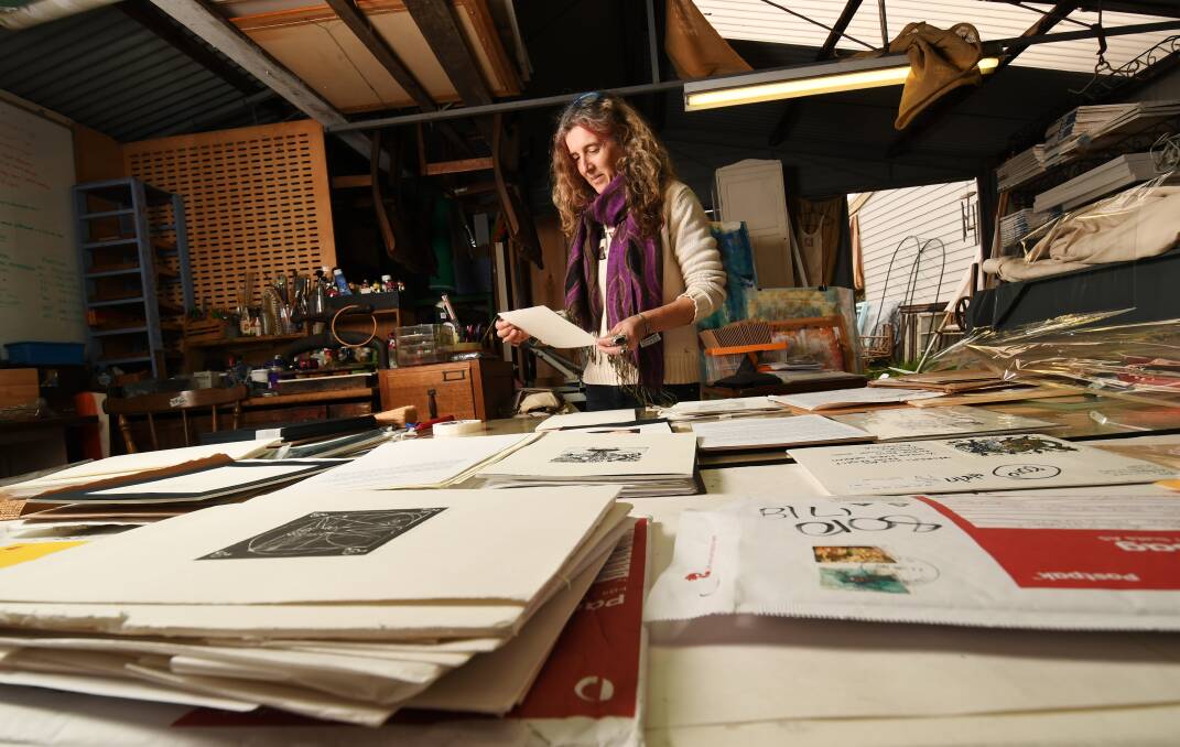 Sophia Graham in her Spring Gully print studio, considering the entries to her art initiative. Picture: DARREN HOWE