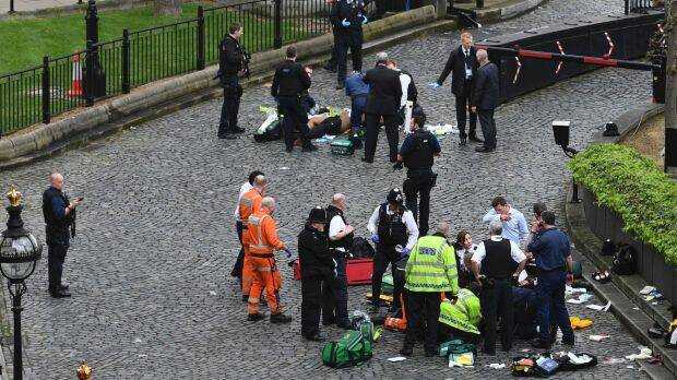 Emergency services attend to injured people outside the Palace of Westminster, London,  Photo: AP