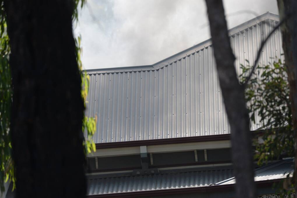 Smoke lingered about the roof of the Kennewell Street property. Picture: DARREN HOWE