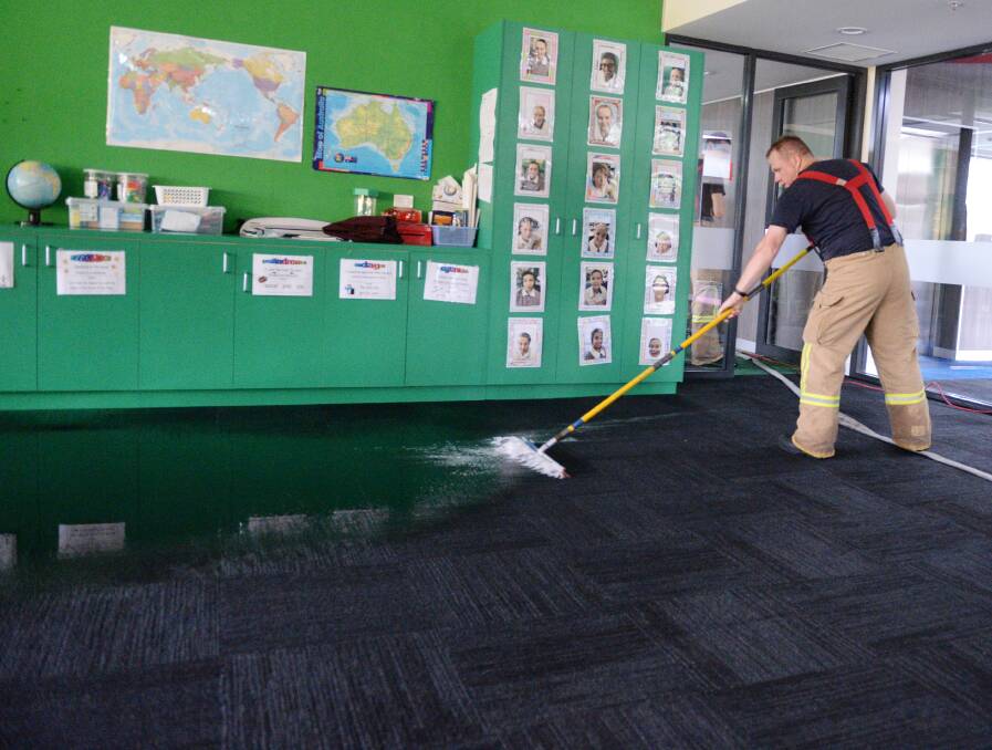 Firefighters clean up flooding at Girton Grammar School. Picture: DARREN HOWE