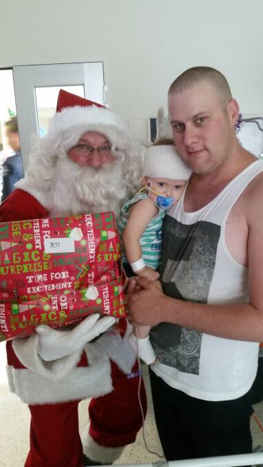 CHRISTMAS WISH: Santa, Jett Hamley and his father Ash Hamley at the Royal Children's Hospital on Christmas day. Pictures: SUPPLIED