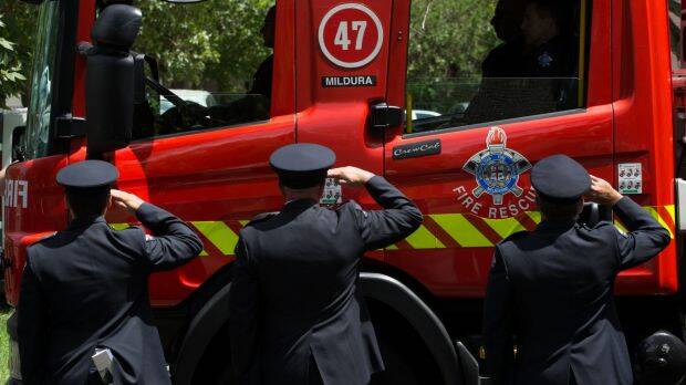 Firefighters salute as a firetruck from Mildura emblazoned with the number 47 drives past. Photo: Jason South