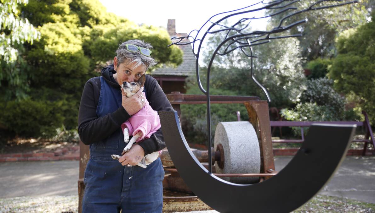 ART FOR A CAUSE: Sculptor Yvonne George and her dog Taj share a cuddle beside one of the works to be showcased on Saturday. Picture: EMMA D'AGOSTINO