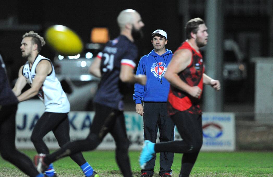 HARD AT WORK ON THE TRACK: North Bendigo coach Rob Bennett watches his players go through their paces at training on Thursday night ahead of Saturday's battle with Leitchville-Gunbower. Picture: NONI HYETT