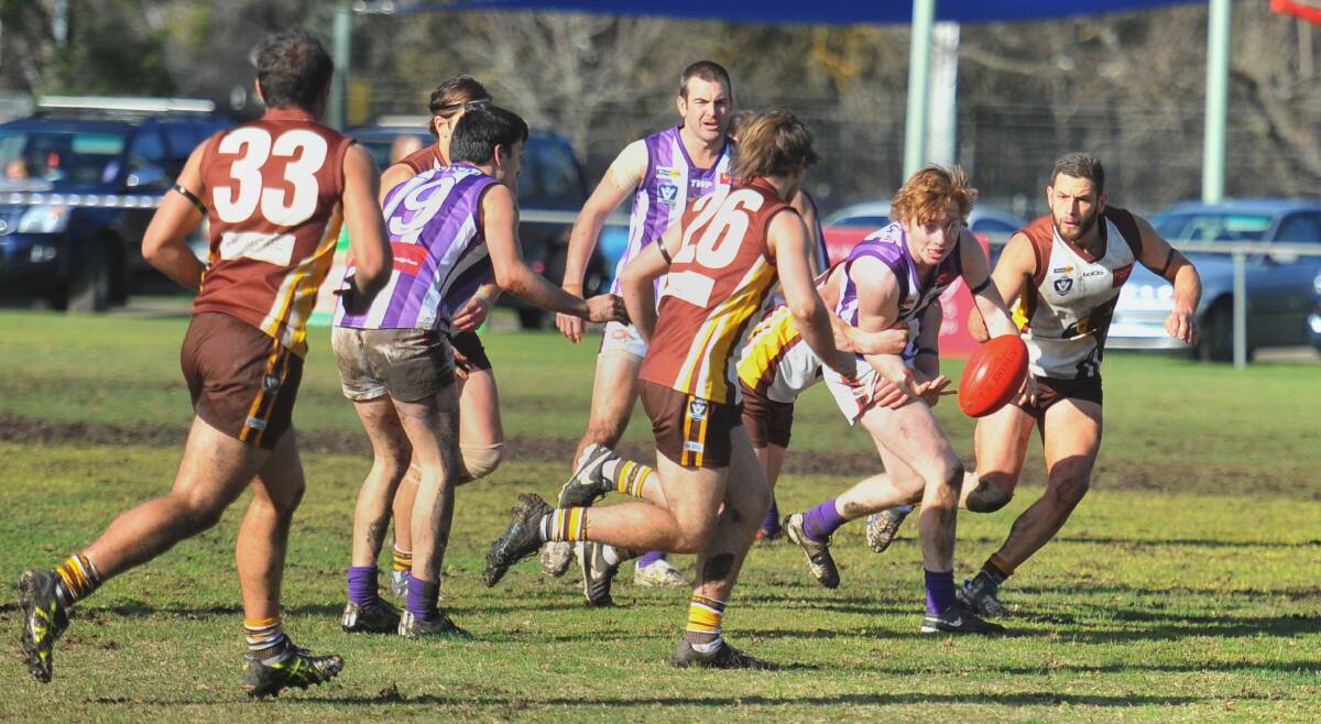 PACK SWARMS: Heathcote's Dillon Hardy prepares to be swooped on by a cluster of Huntly players on Saturday. The Hawks beat the Saints by 77 points. Pictures: LUKE WEST