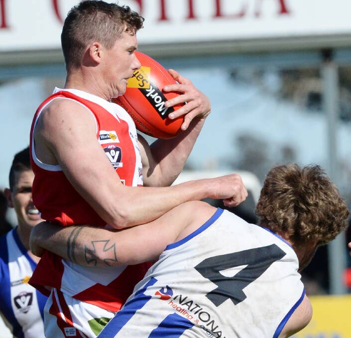 UNDER PRESSURE: Bridgewater coach Andrew Collins is tackled by Mitiamo's Tom Grant on Saturday. The Mean Machine defeated the Superoos by 56 points in the LVFL grand final. Picture: DARREN HOWE