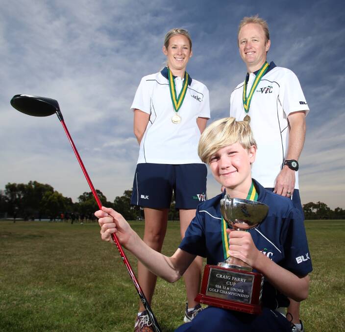 WINNERS ARE GRINNERS: Kennington Primary School's Morten Hafkamp holds the Craig Parry Cup with teachers Alicia Rady and Todd Canobie, who were Victorian team managers. Picture: GLENN DANIELS