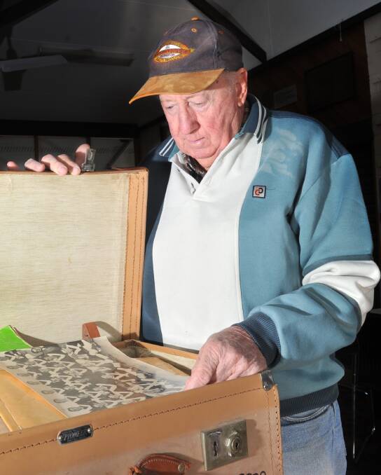 Inglewood Football-Netball Club life member Les Miller looks through a case of memorabilia ahead of the 140th anniversary celebrations this weekend. Picture: NONI HYETT