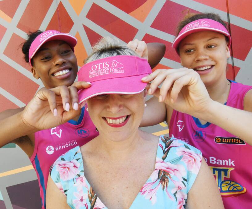 PINK FOR A CAUSE: Spirit imports Betnijah Laney and Rachel Banham with the Rachel Mason from the OTIS Foundation. Picture: DARREN HOWE