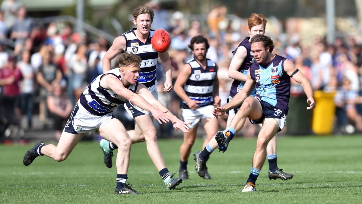 HOT CONTEST: Strathfieldsaye's Jake Moorhead attempts to smother Eaglehawk coach Josh Bowe's kick during Saturday's BFNL grand final at the QEO. The strong-finishing Storm won by 32 points. Picture: GLENN DANIELS
