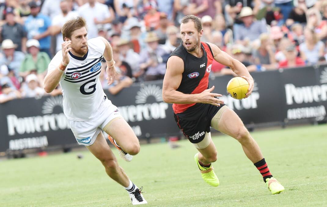 CATCH ME IF YOU CAN: Essendon's James Kelly leads Geelong's Tom Lonergan during Sunday's clash at the QEO in front of a crowd of 8399. Picture: DARREN HOWE