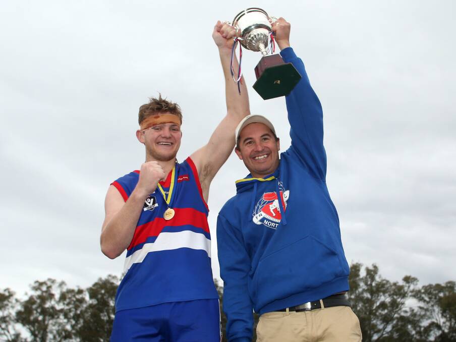 SPOILS OF VICTORY: North Bendigo premiership captain Jordan Ford and coach Rob Bennett hold aloft the 2016 cup. The Bulldogs last won back to back in 1976-77.