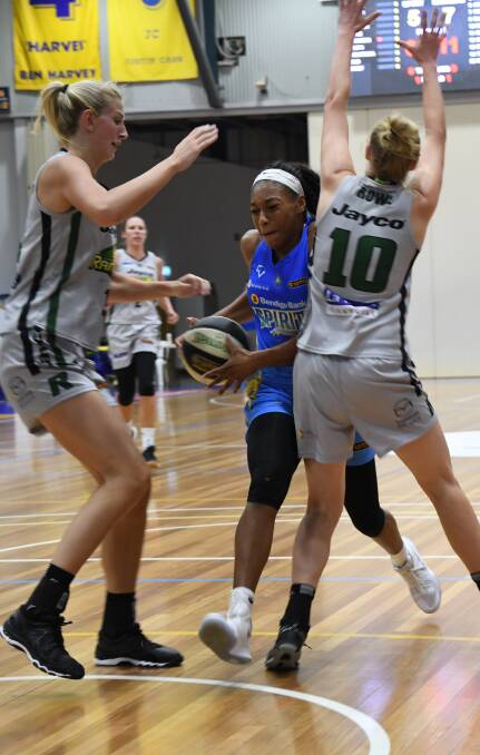 AGGRESSIVE: Bendigo Spirit import Betnijah Laney drives to the basket while she's defended by Dandenong's Carley Mijovic and Kiera Rowe on Thursday night. Laney scored 15 points in the Spirit's win. Picture: LUKE WEST