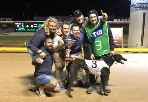 WINNERS ARE GRINNERS: Members of the Peckerheads syndicate with their greyhound Crook Me Kindly after winning the Northern Districts Cup.