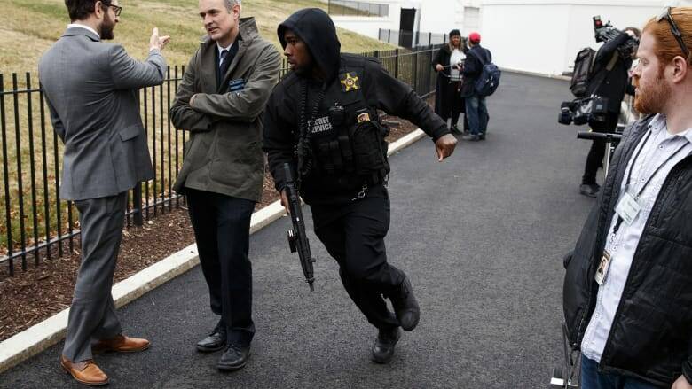 A Secret Service officer rushes past reporters after a vehicle rammed into a security barrier. Picture: AP