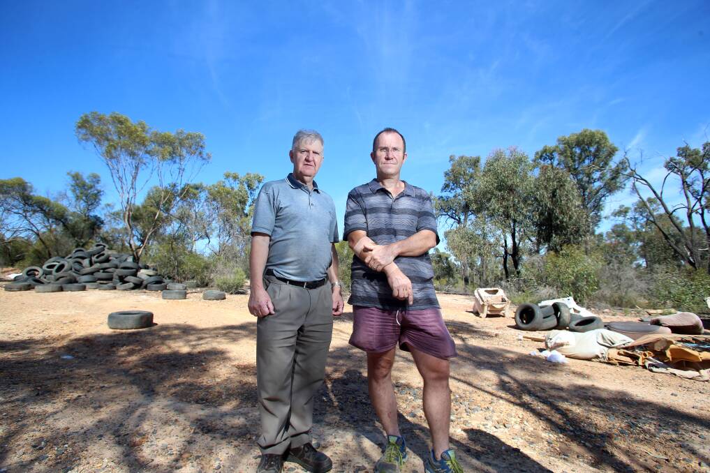 SICK AND TYRED: Locals Laurie Fitzgerald and Alan Hanson are appalled by the dump of hundreds of tyres and syringes. Picture: GLENN DANIELS