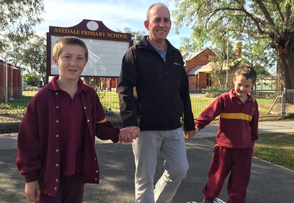 SAFE CROSSINGS: Axedale Primary School principal Lex Johnstone crosses the McIvor Highway, which fronts the school, with students Matt Brown and Sam Doak. 