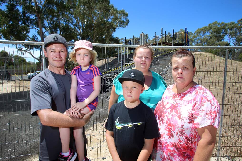 Michael Cason and his daughter Charlotte with Lachlan Hulls, Sophie Hamilton and Michele Hulls in front of the burnt down slide at Cooinda Park.