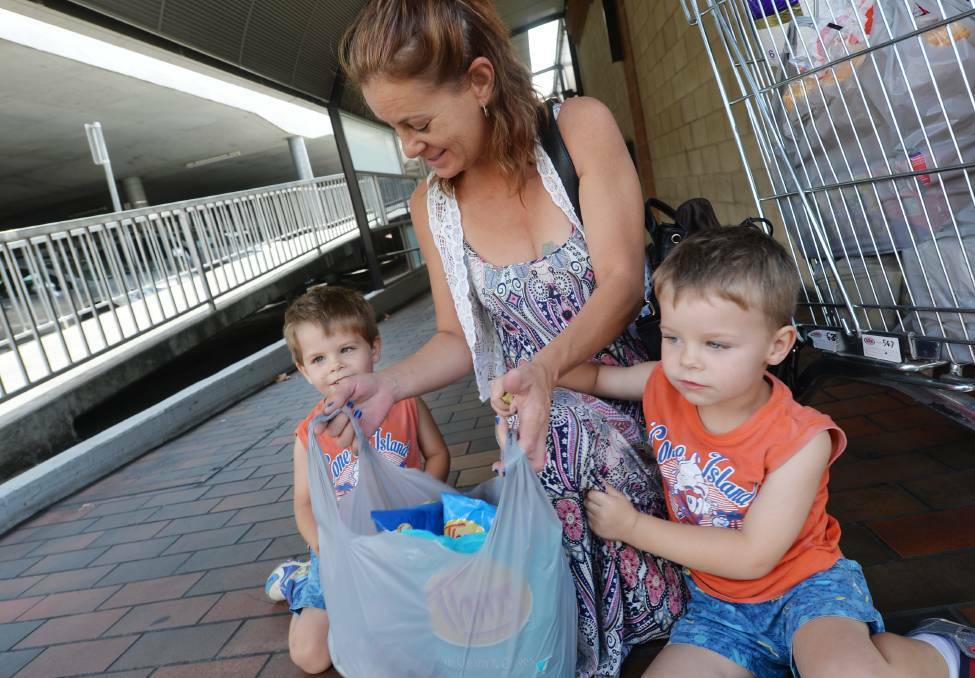 Terrie Steve, with her sons Hunter and Chase, after leaving Coles Bendigo with a trolley full of plastic bags. Picture: DARREN HOWE
