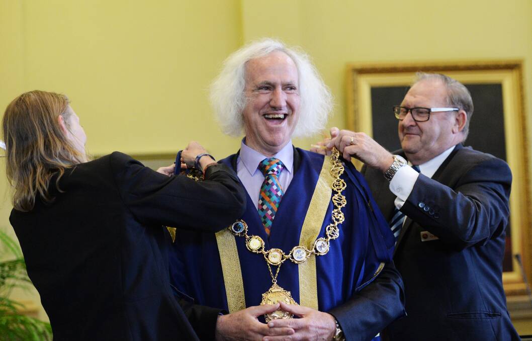 Councillors Elise Chapman and Barry Lyons don Cr Rod Fyffe with the robe and chain of the mayor's office. Pictures: DARREN HOWE