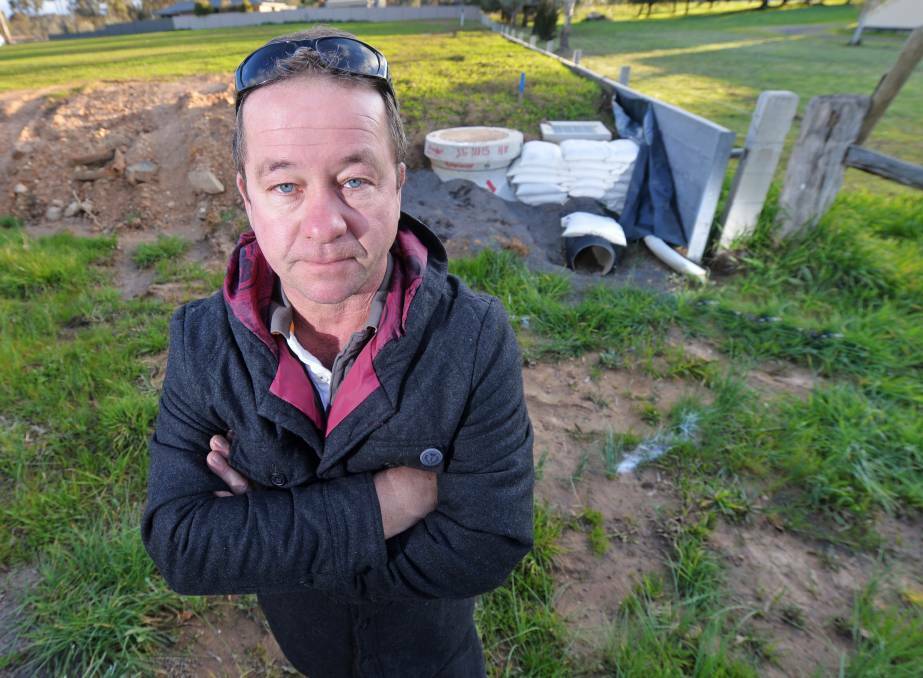 DRAIN PAIN: Truck driver Steve Pilcher and his family are one of eight households who were initially outraged by plan which would see them fork out thousands to pay for the drainage upgrade - when they sell the land. Picutre: DARREN HOWE
