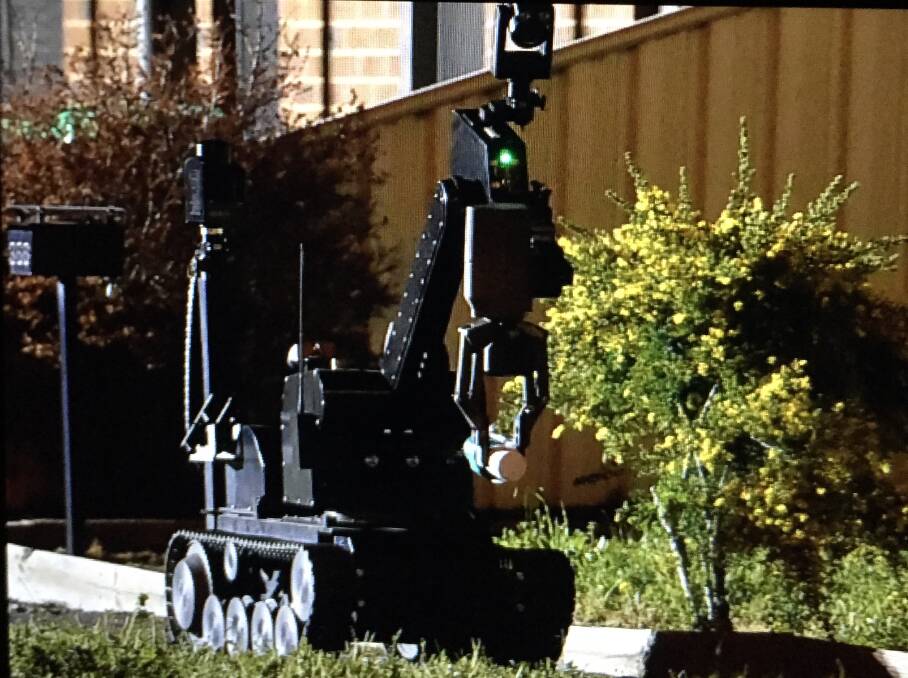 The remote-controlled robot removes the suspicious package from the yard in White Hills. Picture: DARREN HOWE