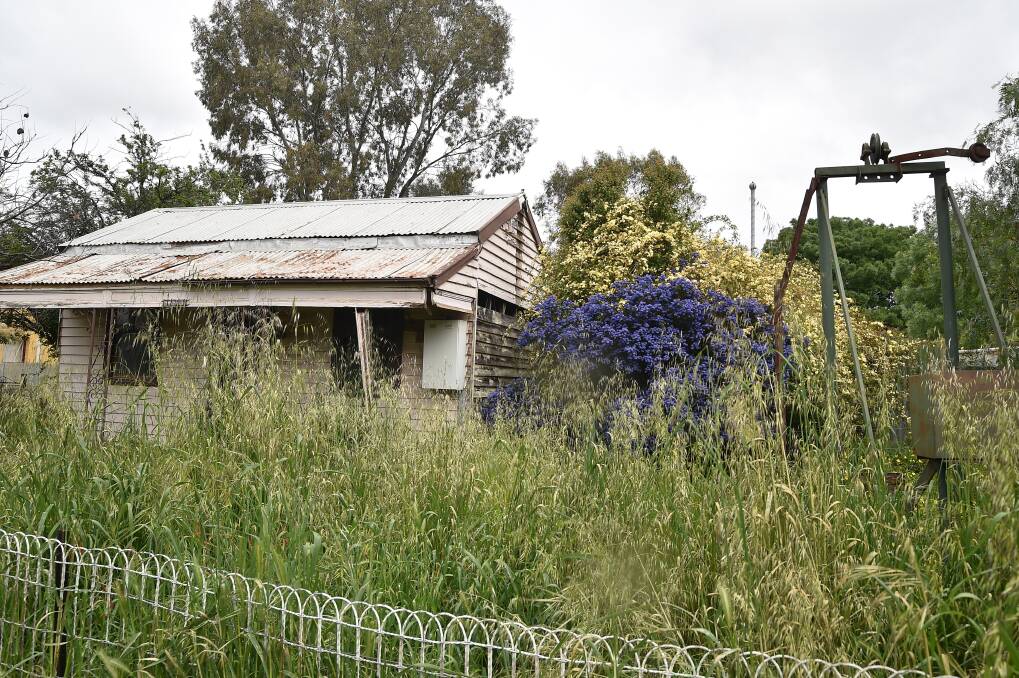 DIVE OR DIAMOND IN ROUGH?: Councillors will decide whether to allow the demolition of this Hall Street miner's cottage, seen here with a poppet head in the front yard. Picture: NONI HYETT