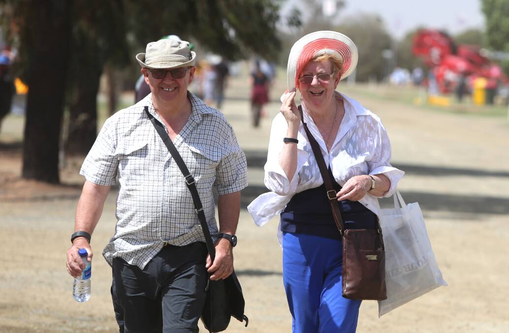 Travor Lund and Maggie Williams from Bendigo hold on to their belongings as the wind hits.