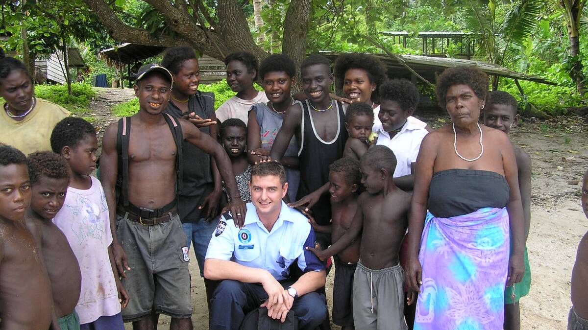SERVICE: Darren Wiseman with villagers in Papua New Guinea. A Victoria Police officer, Mr Wiseman has also been involved in peacekeeping for the Australian Federal Police in different parts of the world. 