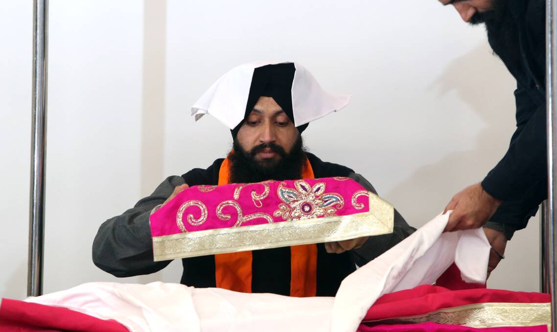 RELIGION: Priest Jasbir Singh at a Sikh event last year. He is holding the Guru Granth Sahib, the Sikh holy book that members will read aloud for more than 48 hours this holiday season. Picture: GLENN DANIELS