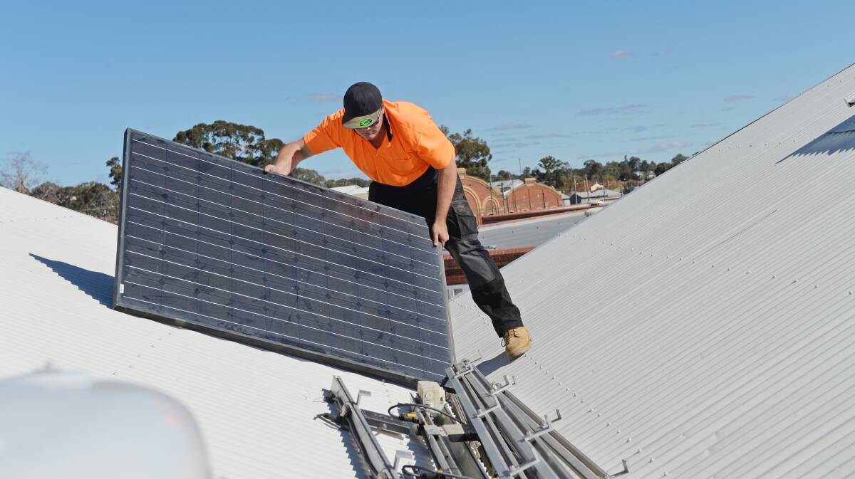 GREEN POWER: Solar panels being installed on the roof of a central Victorian building. Picture: DARREN HOWE