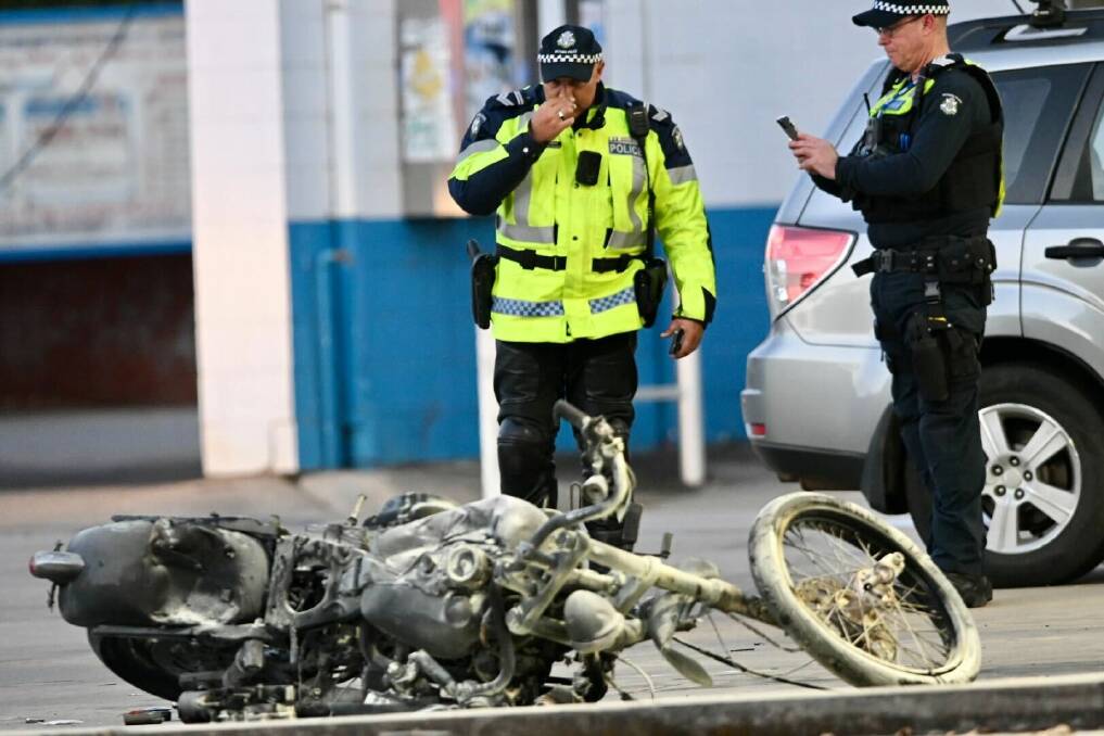 Police officers with the badly damaged motorbike. Picture by Darren Howe.