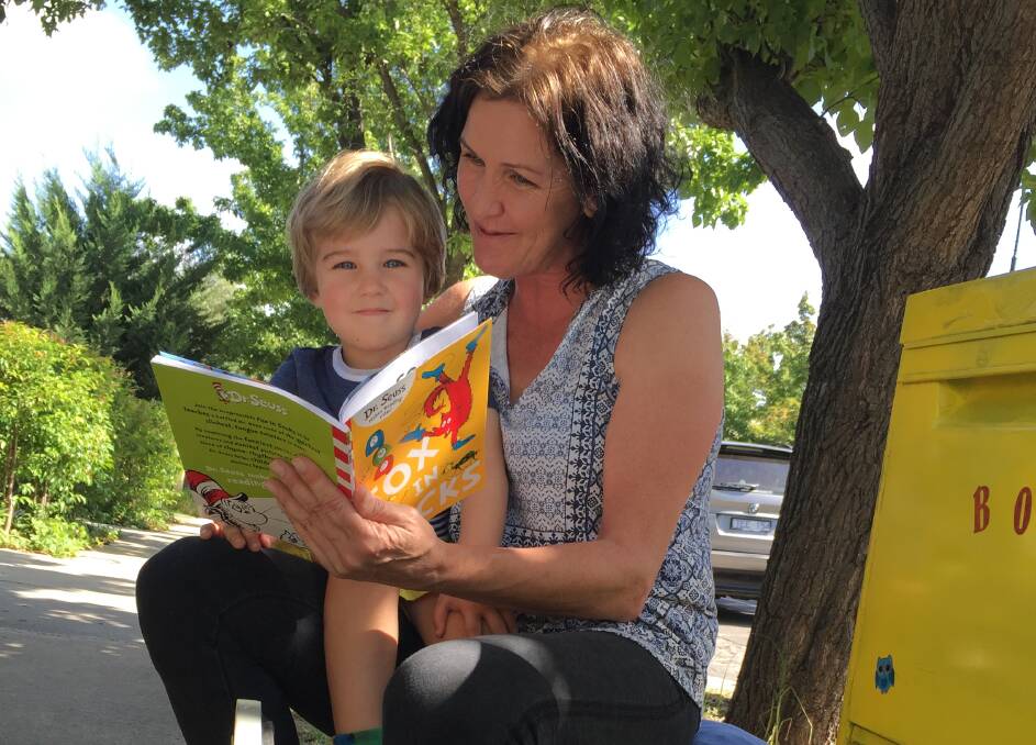 READING TIME: Jett gets to pick out a book from grandmother Robyn Cunnington's nature strip lending library.