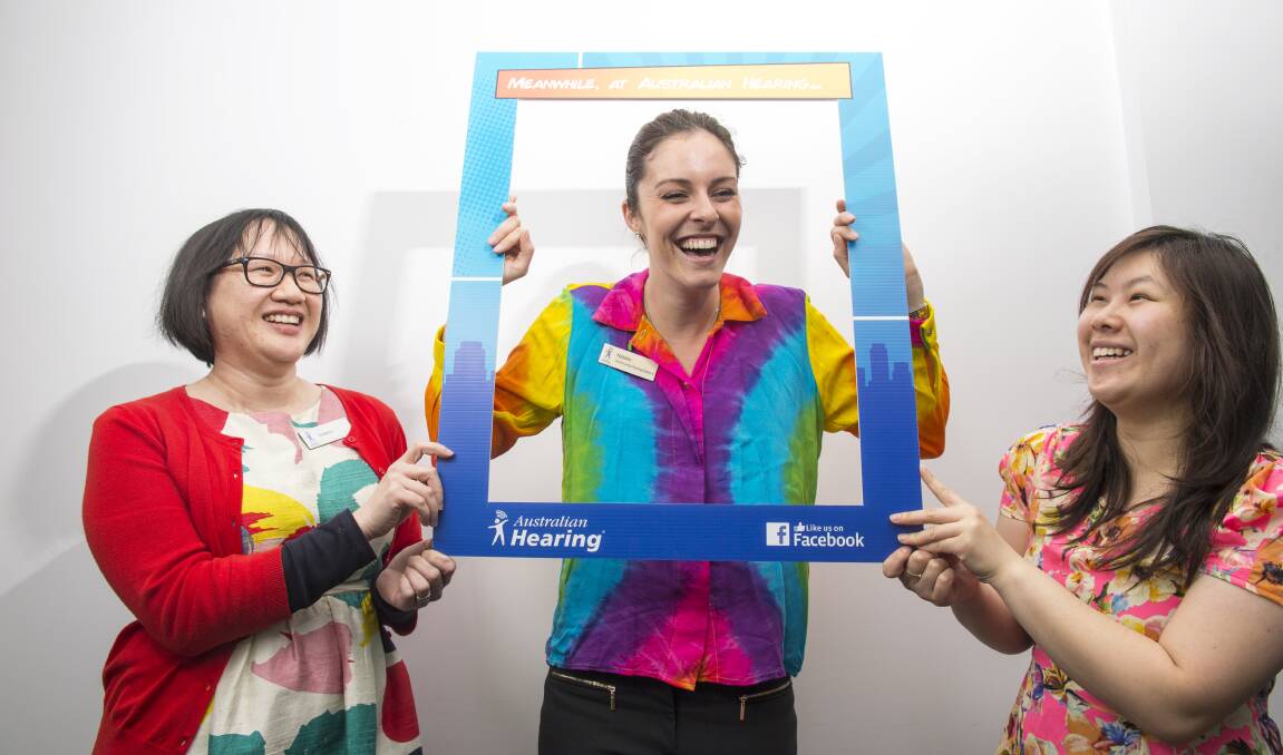 Natalie Martin gets some help from colleagues Suwana Watt and Salvia Ha amid plans for a Loud Shirt Day Instagram campaign. Picture: DARREN HOWE
