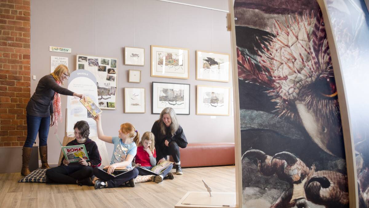 READING TIME: The curators of the exhibition share their love of books with local children. Picture: Lorena Carrington