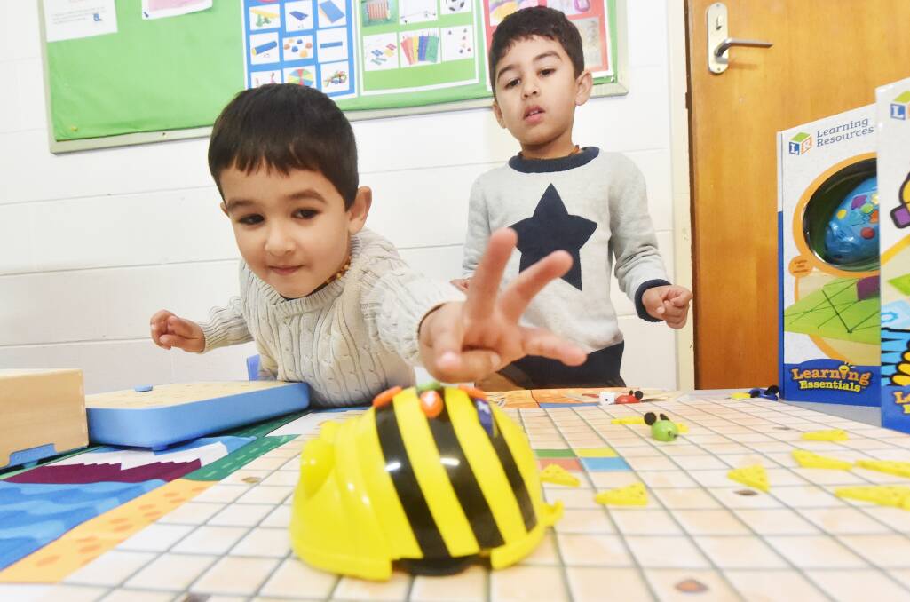 HIGH TECH: Jobe and Tobais Mather play with a Bee-Bot. The toy was purchased for the Bendigo Community Toy Library. Picture: DARREN HOWE